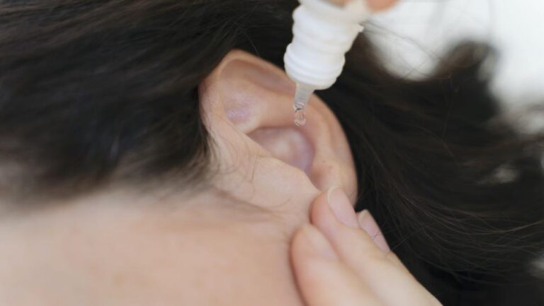 woman putting in ear drops