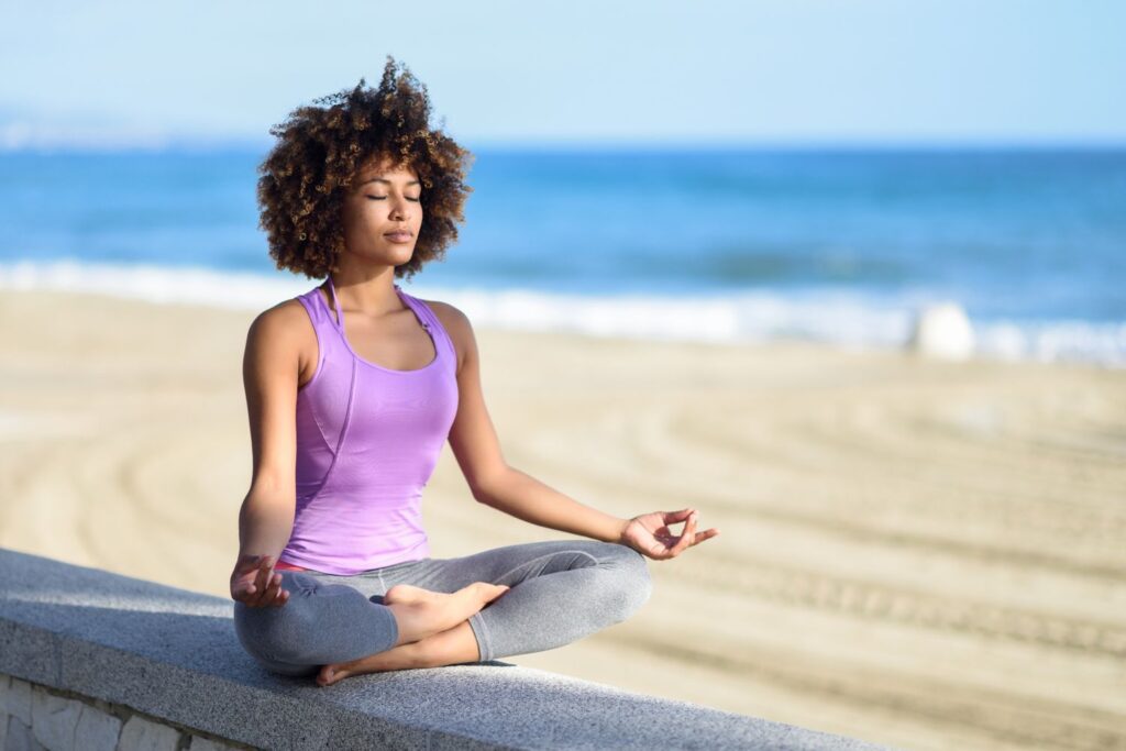 woman meditating on the beach