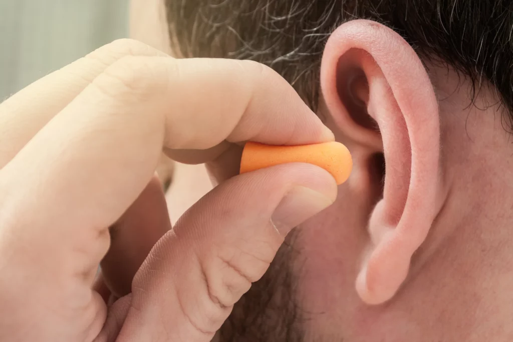 person putting in ear plugs