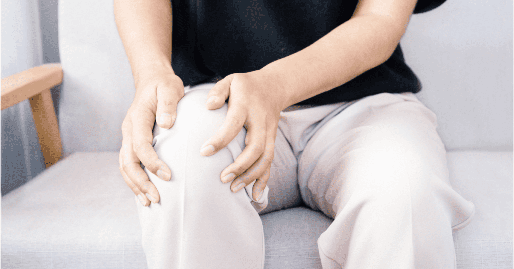 Person in pain holding their knee