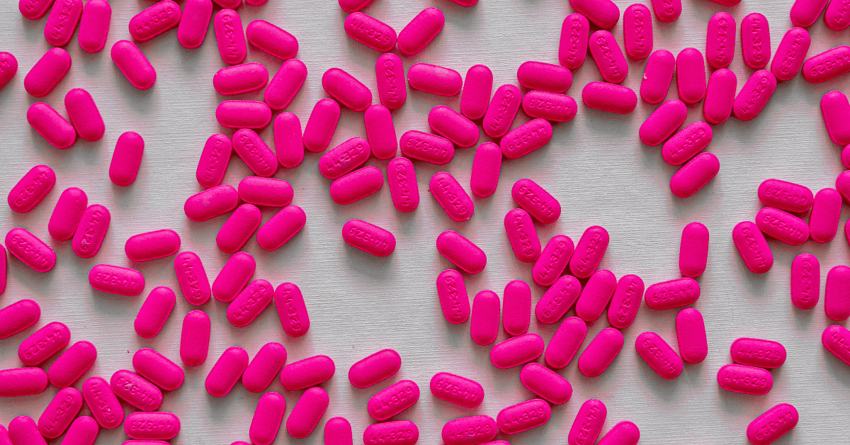 Pink pills scattered on a counter