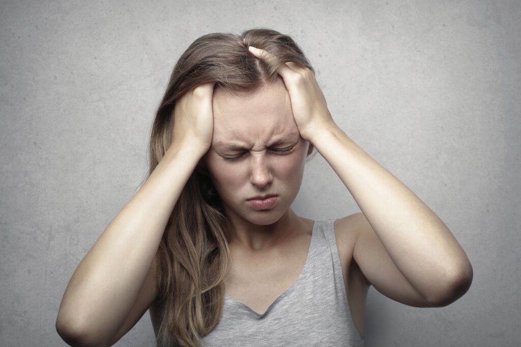 Woman with a headache holding her head in pain