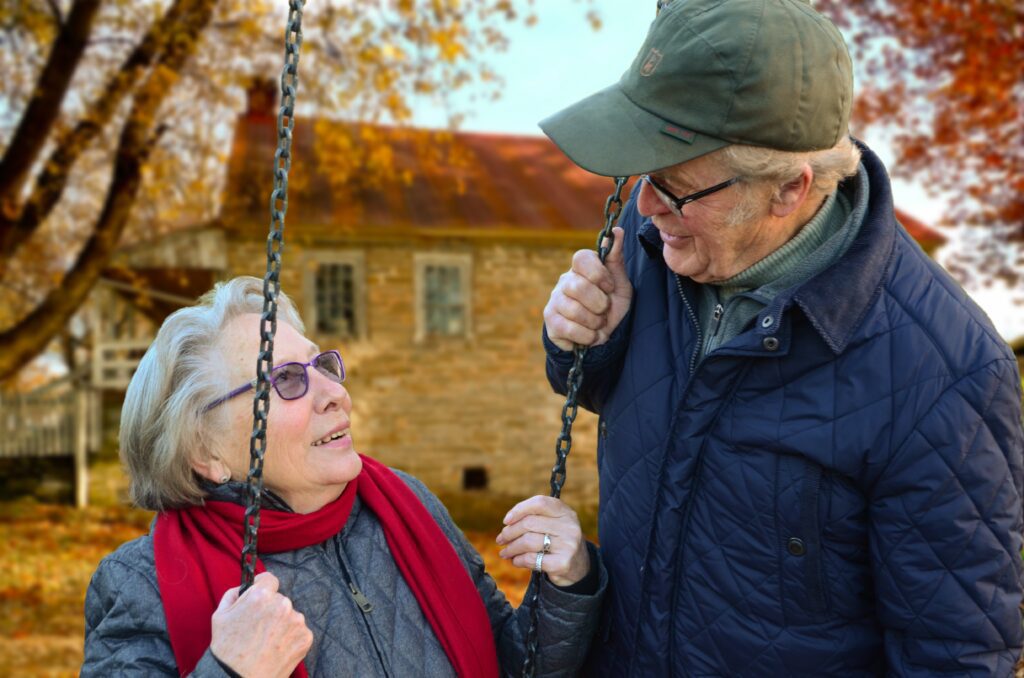 Older couple outside on the swings