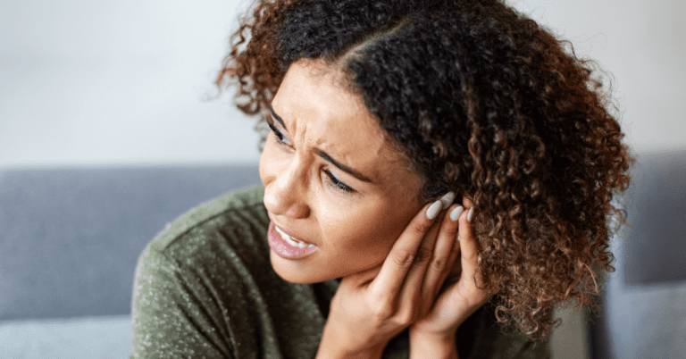 Woman holding her ear in pain