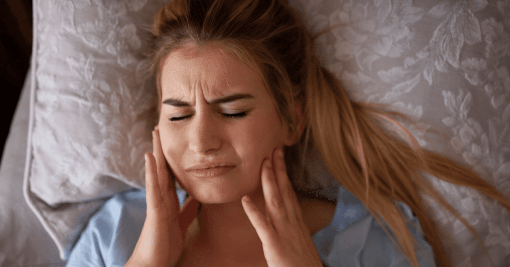 Woman holding her jaw from jaw pain