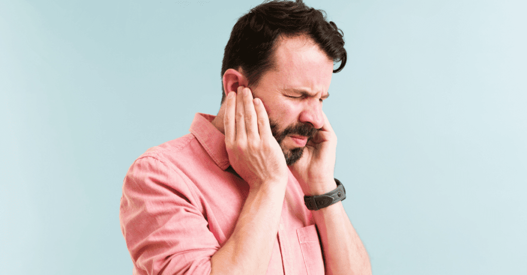 Man holding his ears in pain