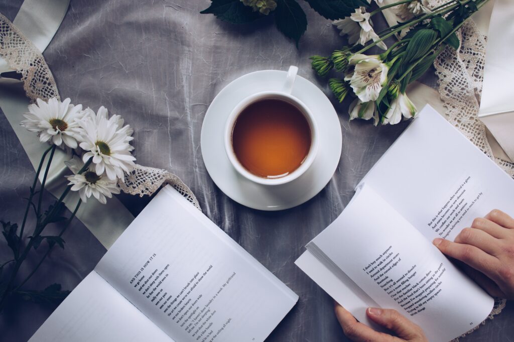 Person reading a book with a cup of tea