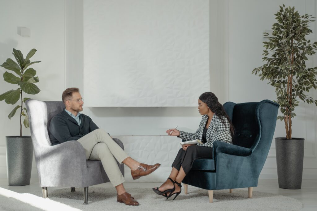 Two people sitting in chairs having a conversation