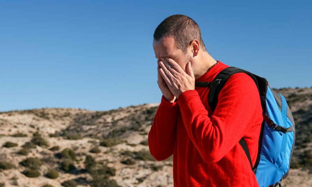 Man covering his eyes 