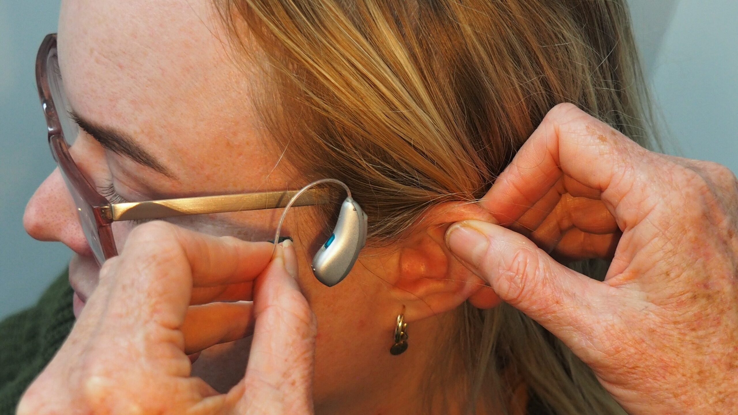 Woman putting hearing aids in