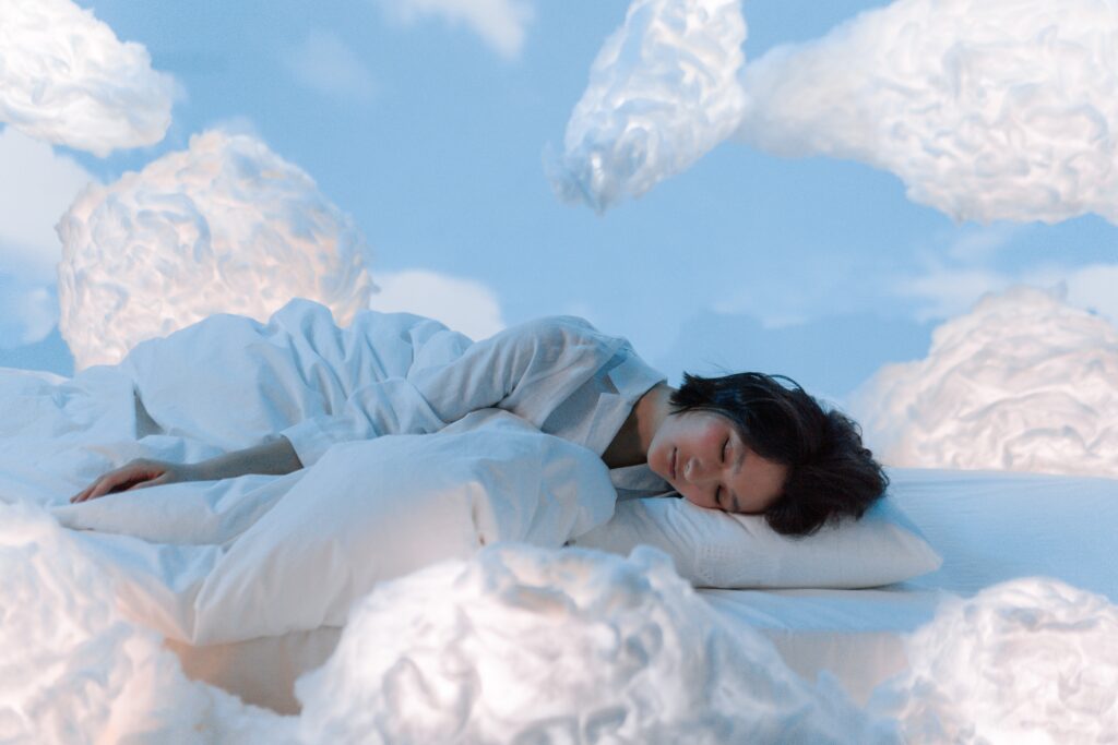 Woman sleeping on a pillow surrounded by clouds