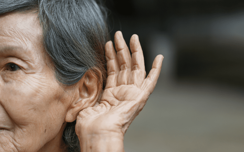 Woman holding her ear to help her hear better