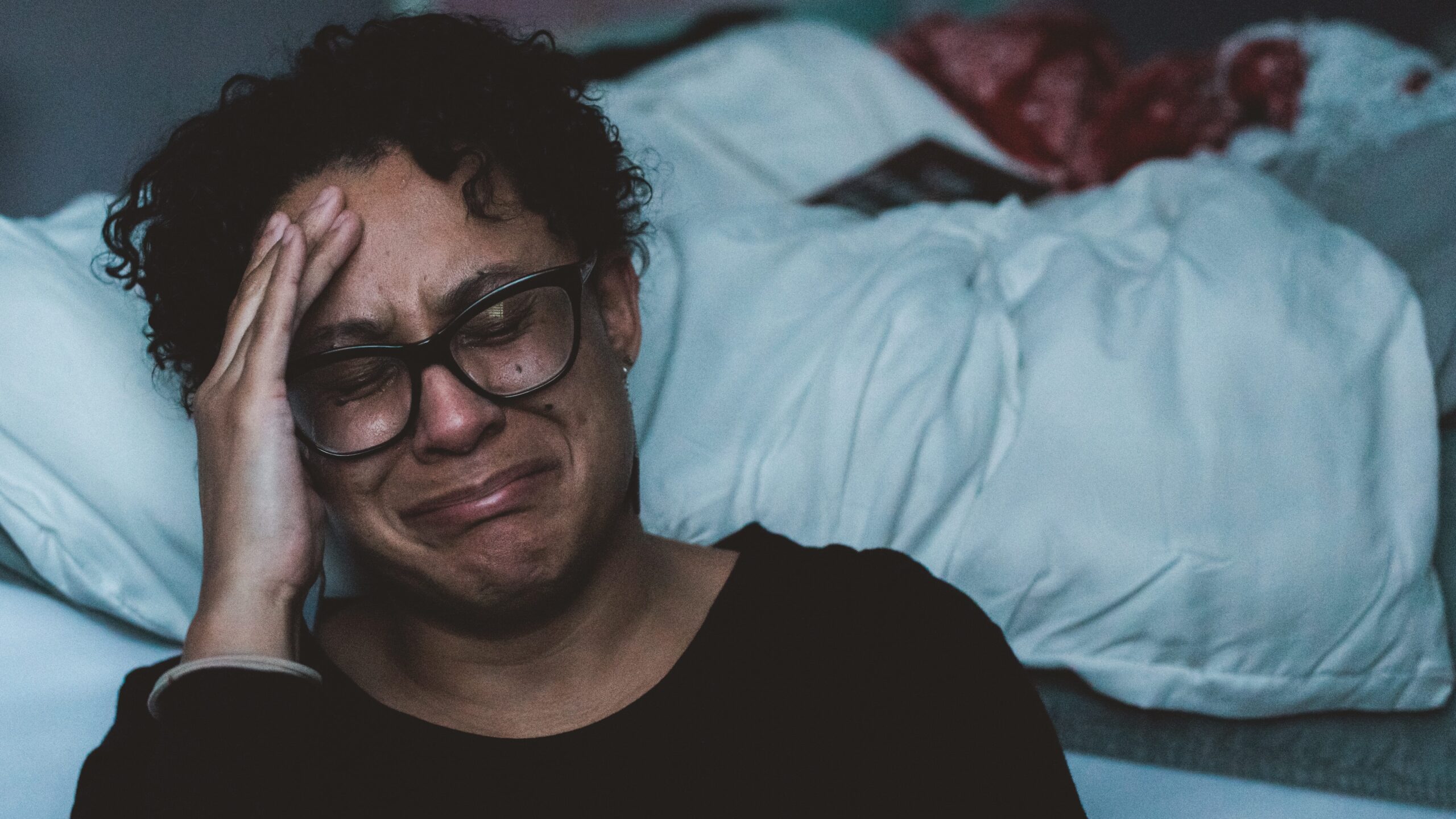 Woman crying with her hand on her head