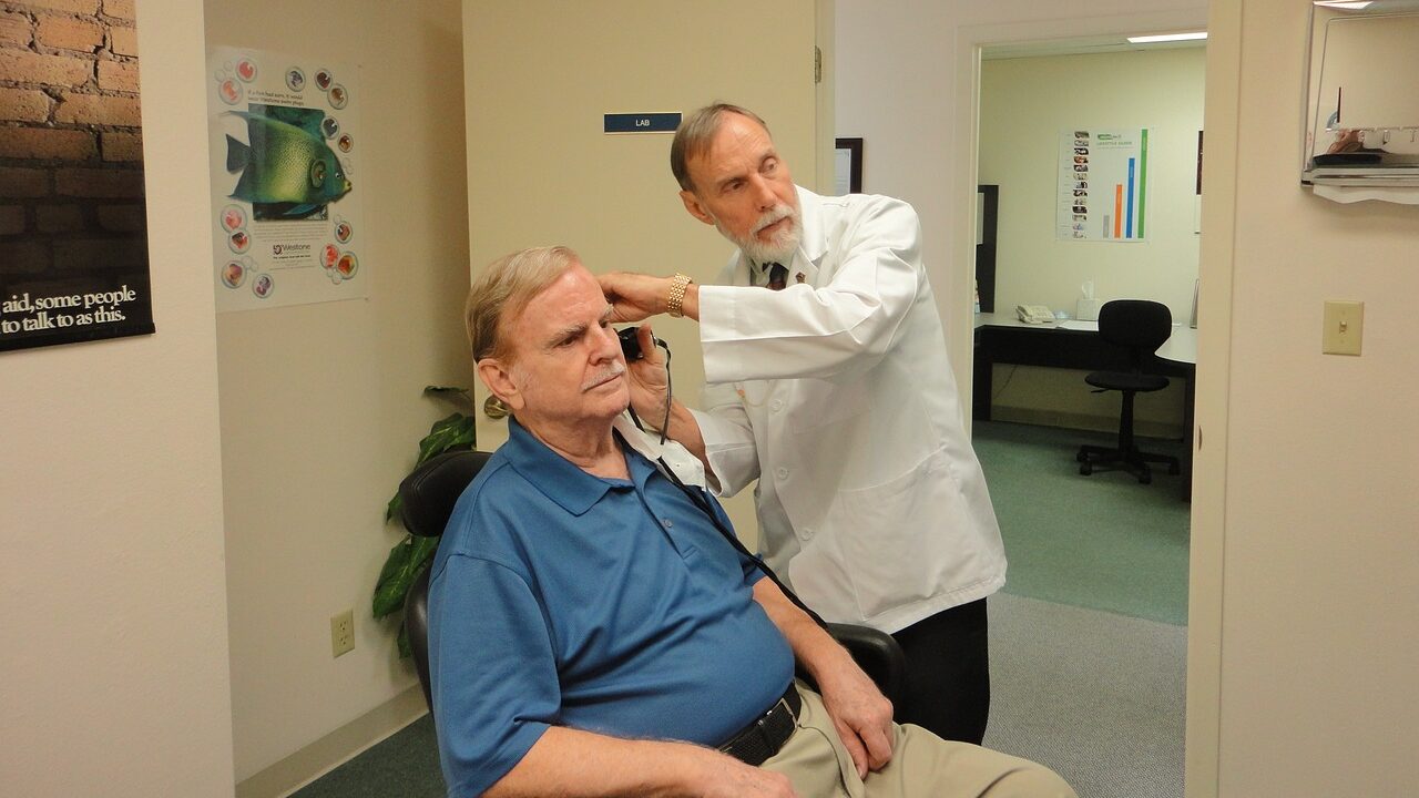 Man getting his ears checked by a doctor