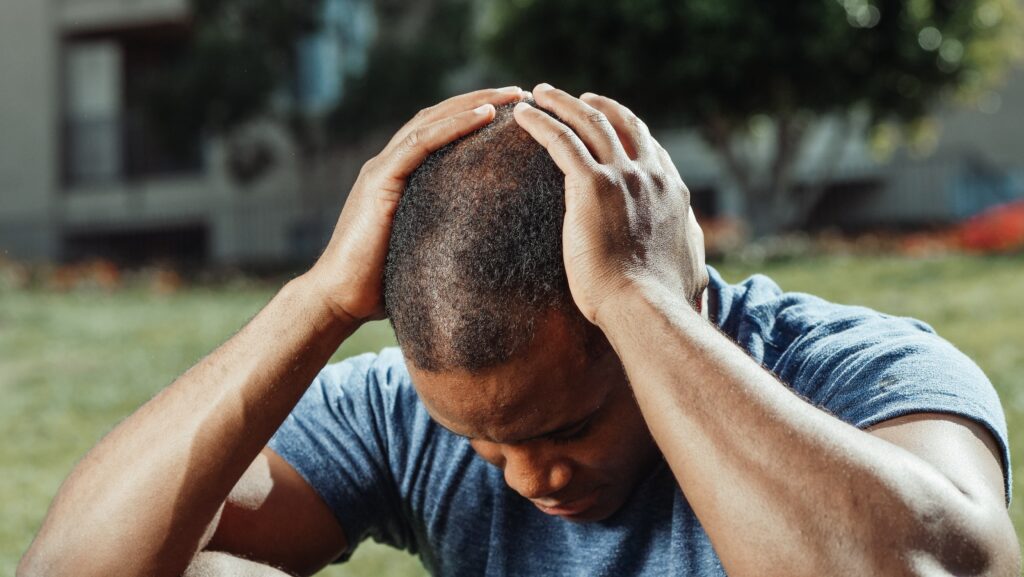 Man with a headache holding his head in his hands 