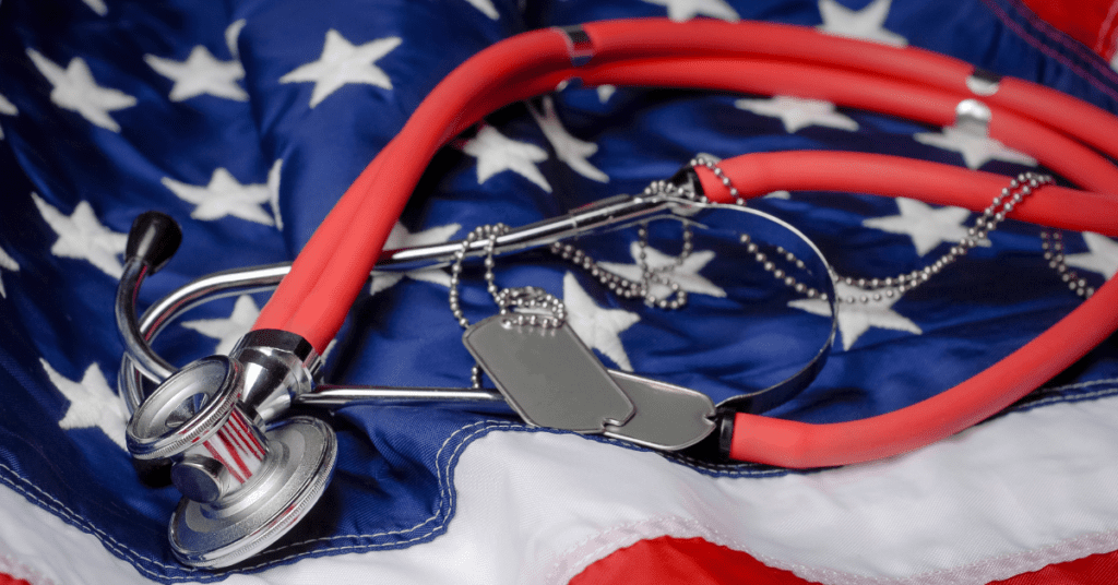 American flag with a stethoscope and military dog tags on top