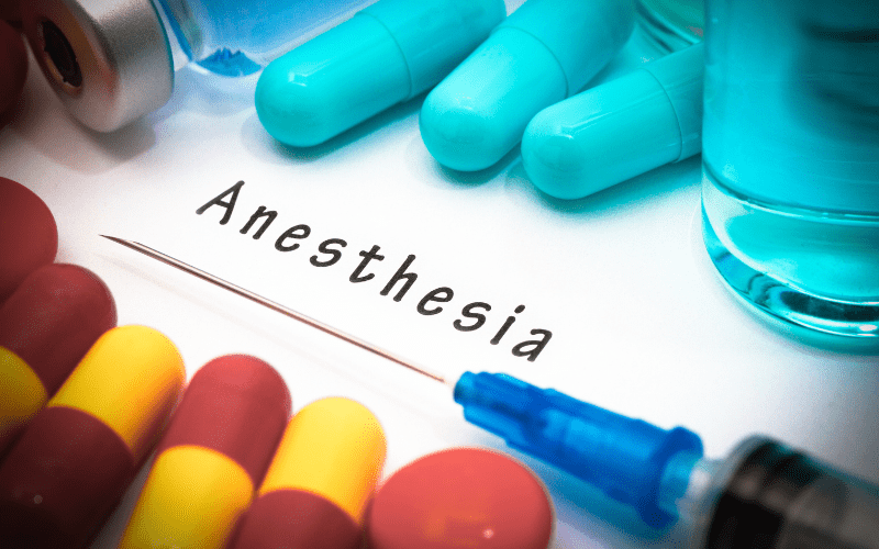 Word anesthesia with syringe and pills next to it
