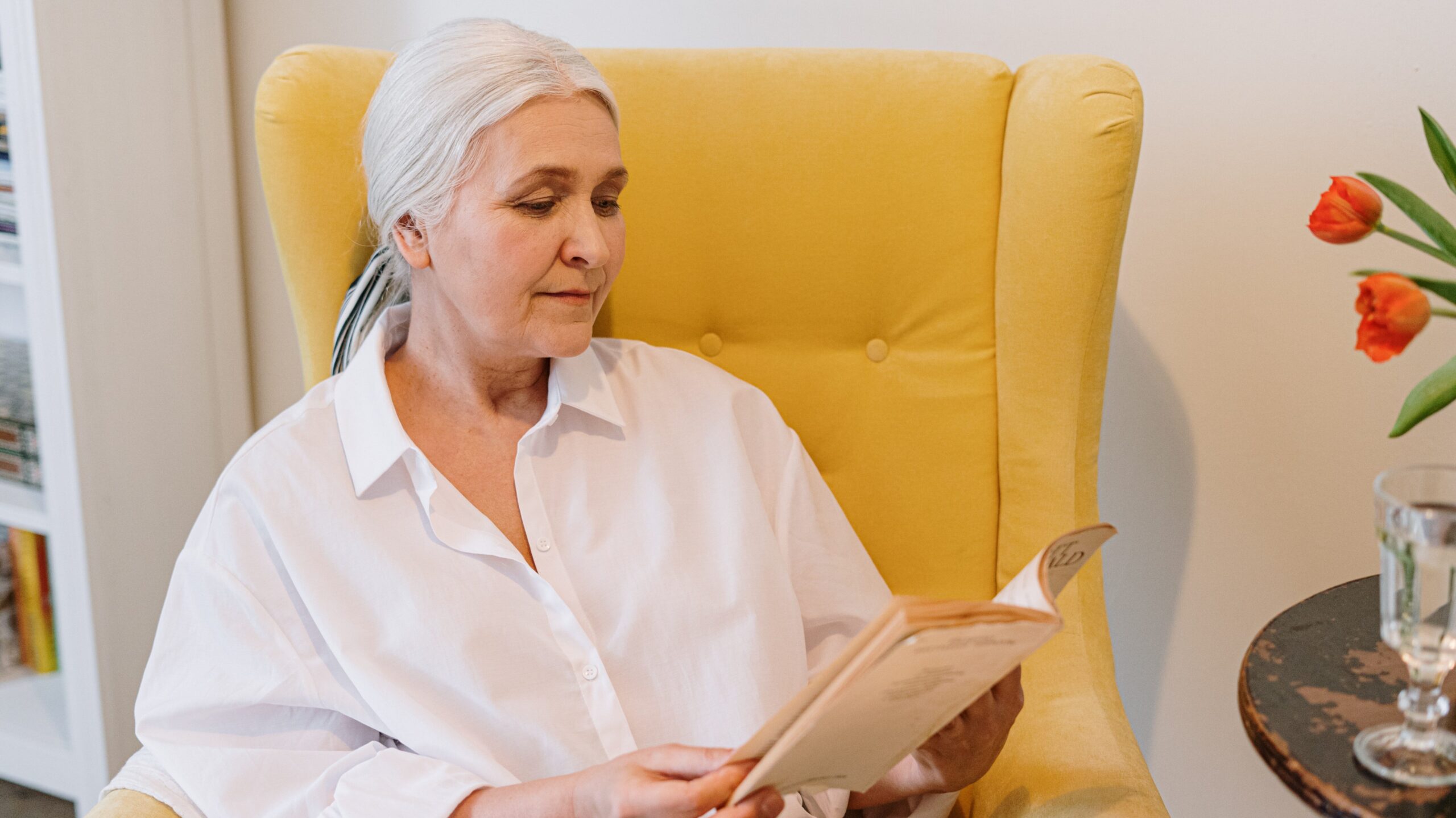 Older woman sitting in a chair reading a book