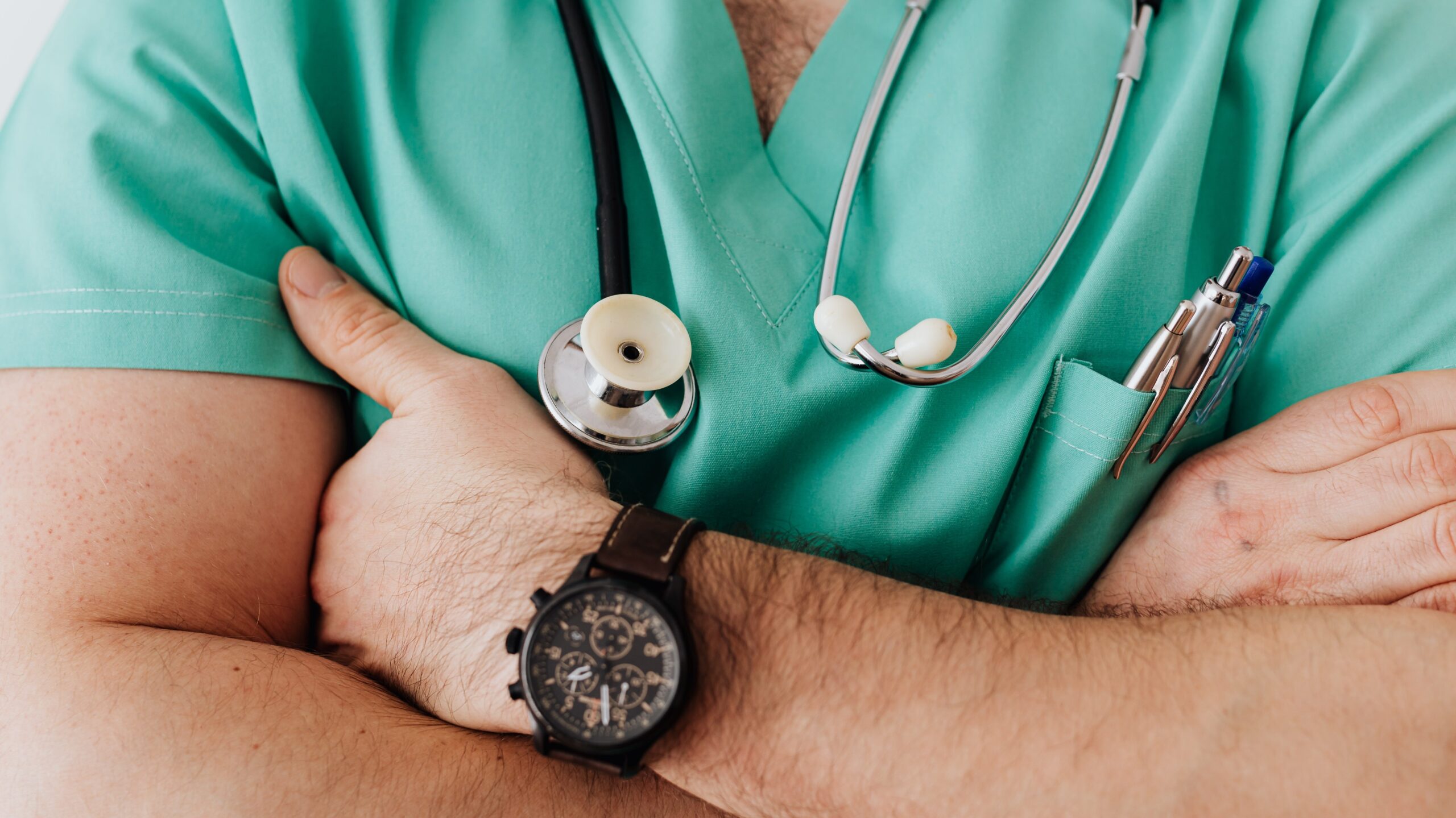 Doctor in scrubs with a stethoscope hanging around his neck