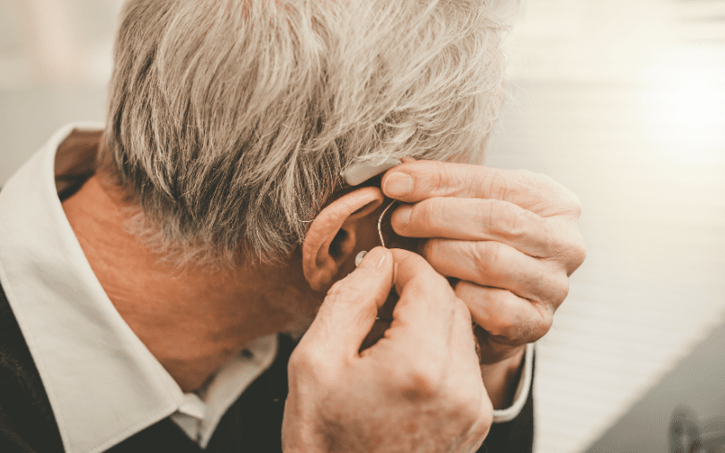 Man putting in hearing aids
