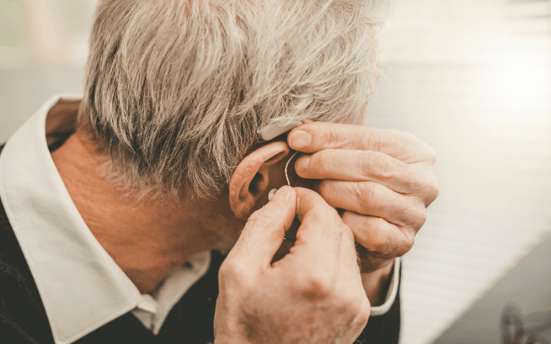 Man putting in a hearing aid