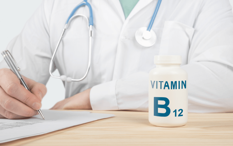 Doctor sitting behind a bottle of B12 supplements 