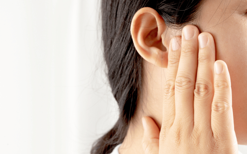 Woman with tinnitus holding her ear