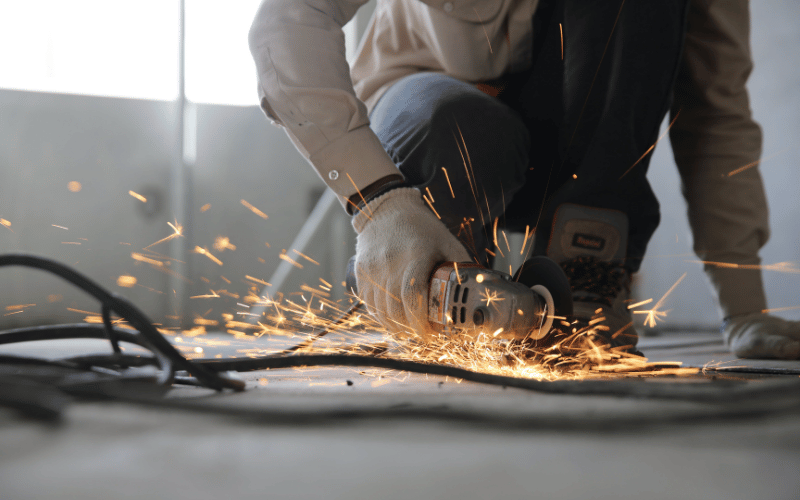 Construction worker grinding metal