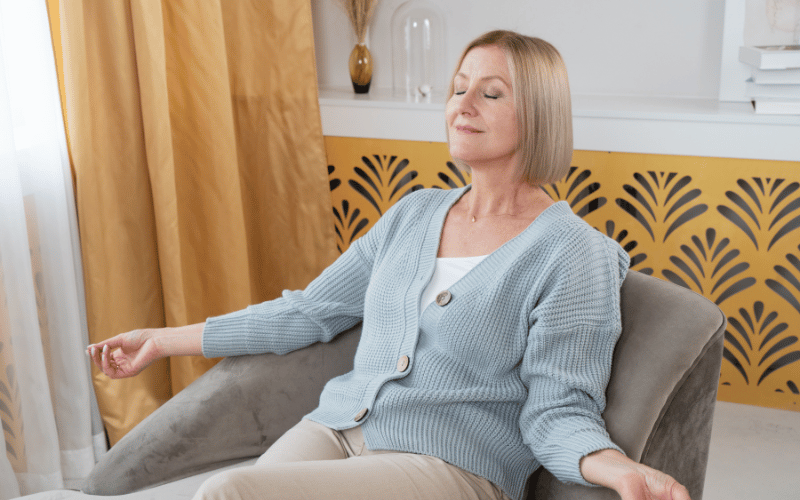 Woman sitting in a chair meditating 