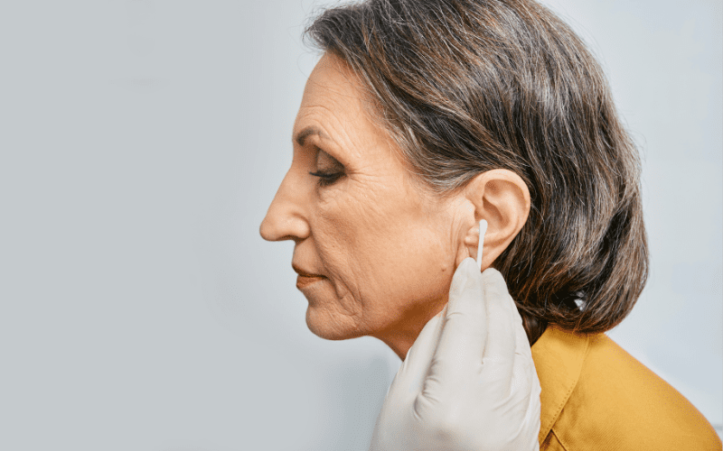 Woman cleaning her ear canals with a Q-Tip