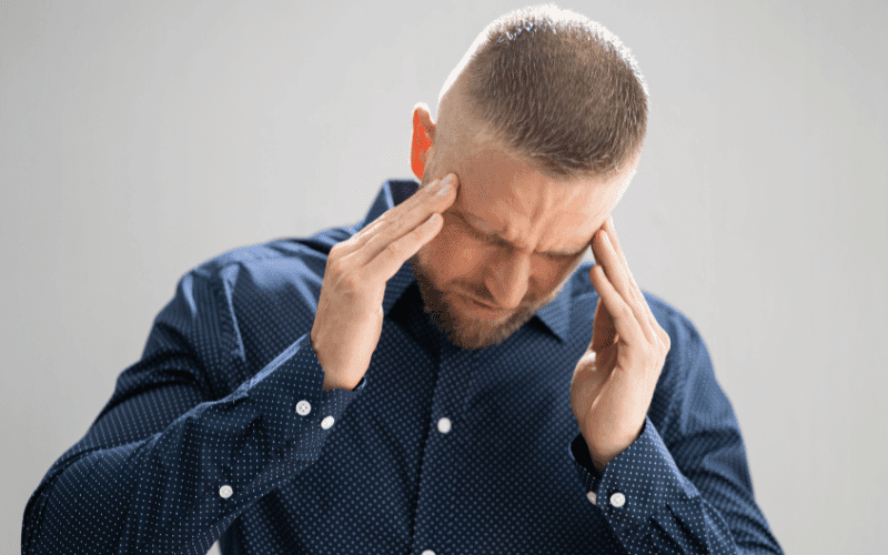 Man with migraine holding his head