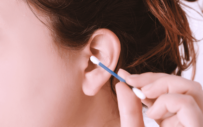 Woman using a Q-Tip to clean her ears