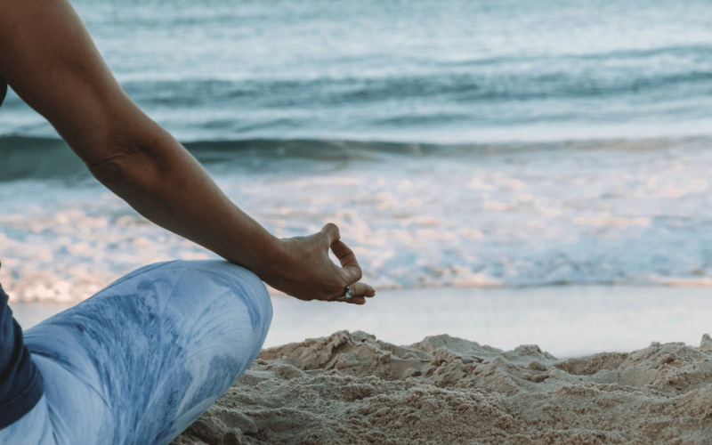 Person meditating on the beach